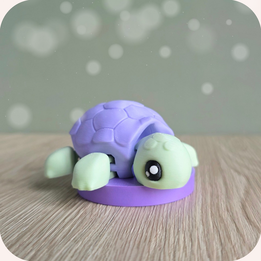 Tortue posée sur socle violet — ALT : figurine tortue articulée kawaii pastel – vue 3/4.